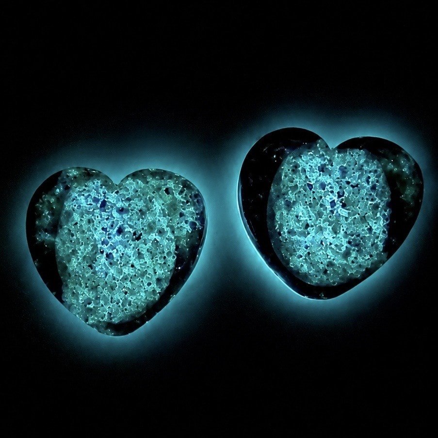Pair of glowing aqua heart-shaped memorial worry stones in the dark — Everclose Jewelry
