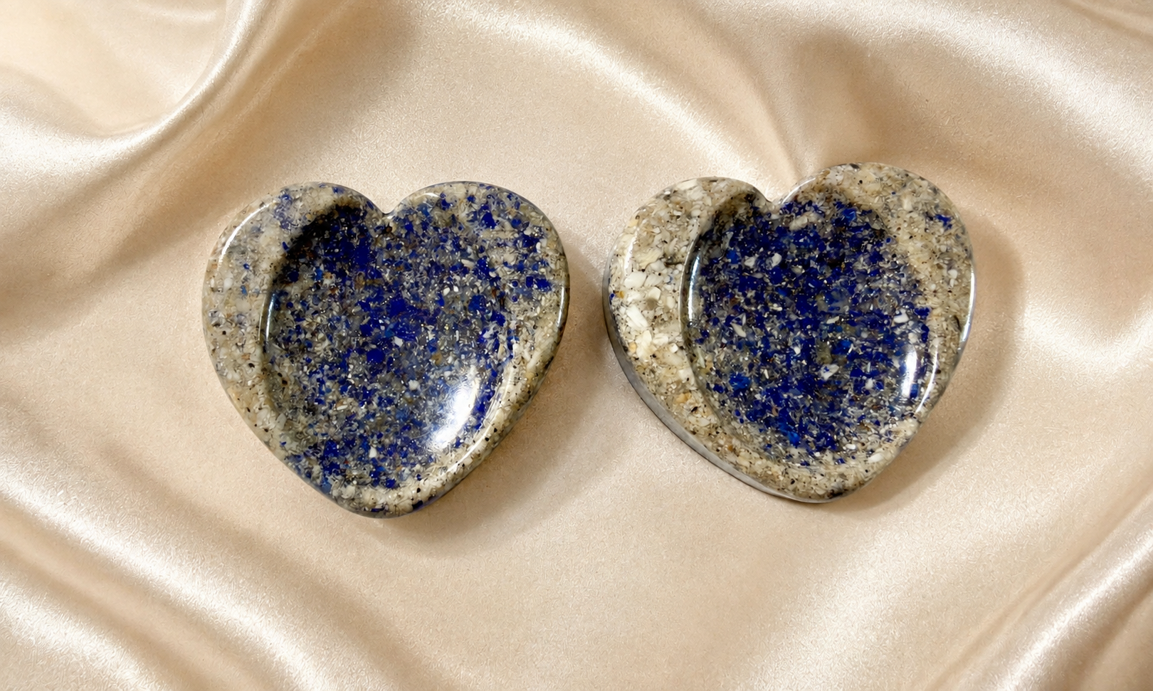 Pair of heart-shaped lapis lazuli memorial worry stones on satin fabric
